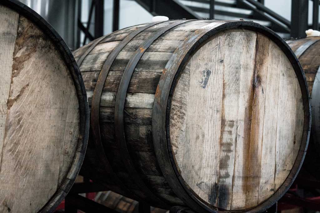 A row of wooden whisky barrels stacked next to each other