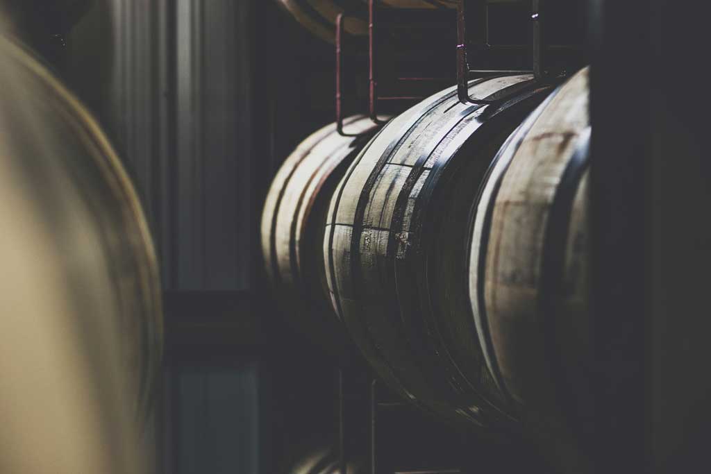 Dark warehouse containing whisky barrels