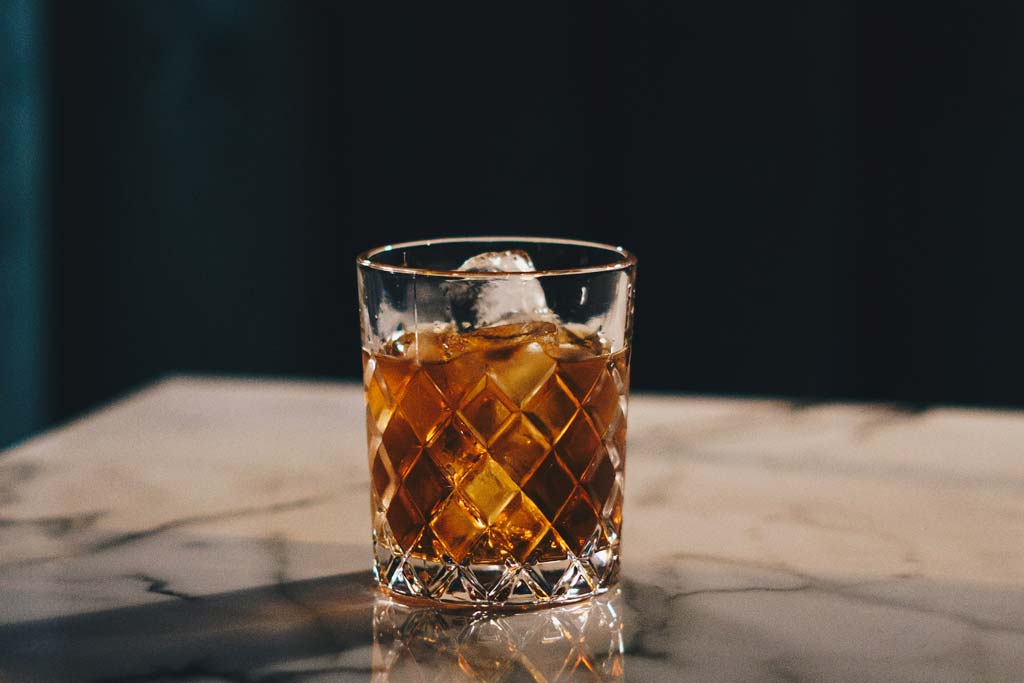 Glass of whisky sitting on marble table