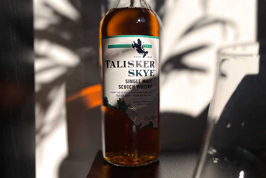 Talisker Skye whisky bottle beside Glencairn drinking glass
