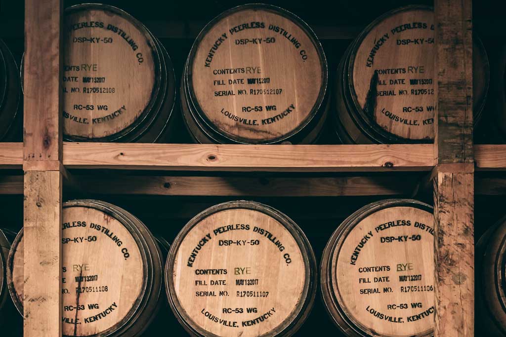 Whiskey barrels stacked on rickhouse shelf