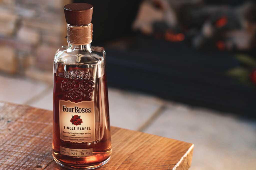 Bottle of Four Roses bourbon sitting on wooden table top