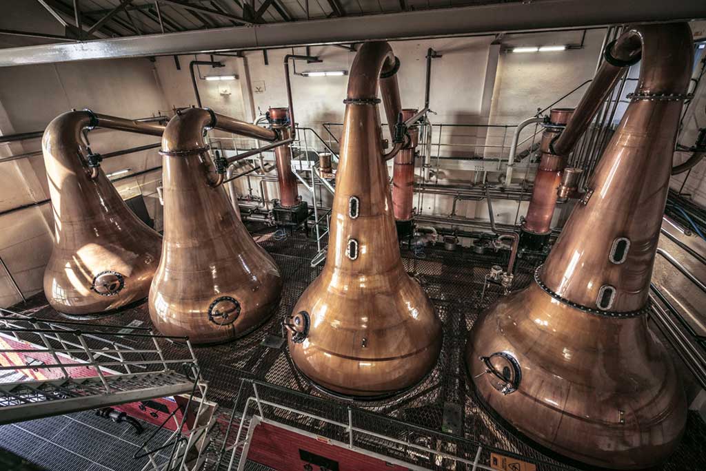 Four large copper whisky stills inside Lagavulin distillery on Islay 