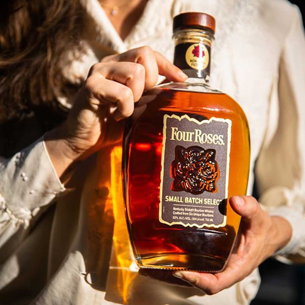 Women holding a bottle of Four Roses Small Batch Select bourbon