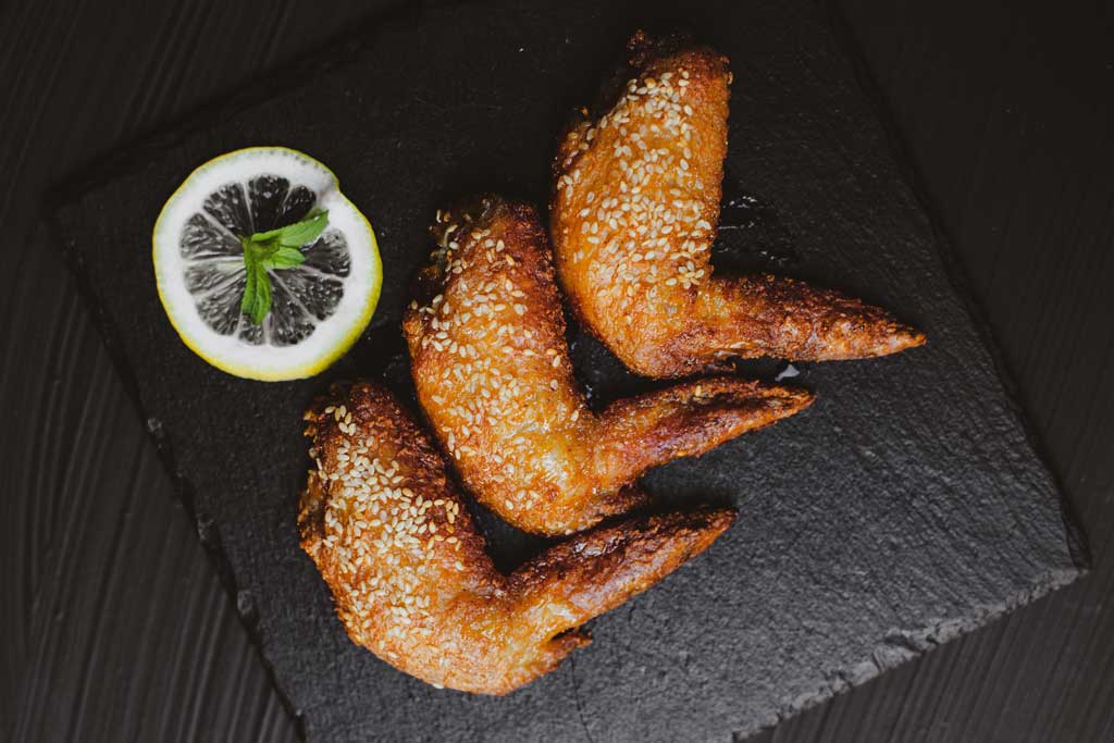 Aerial view of chicken wings on a black slate serving plate