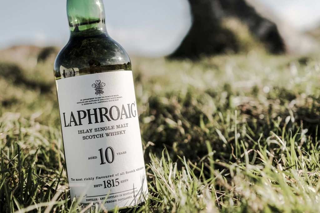 Bottle of 10 year old Laphroaig lying in grass outside