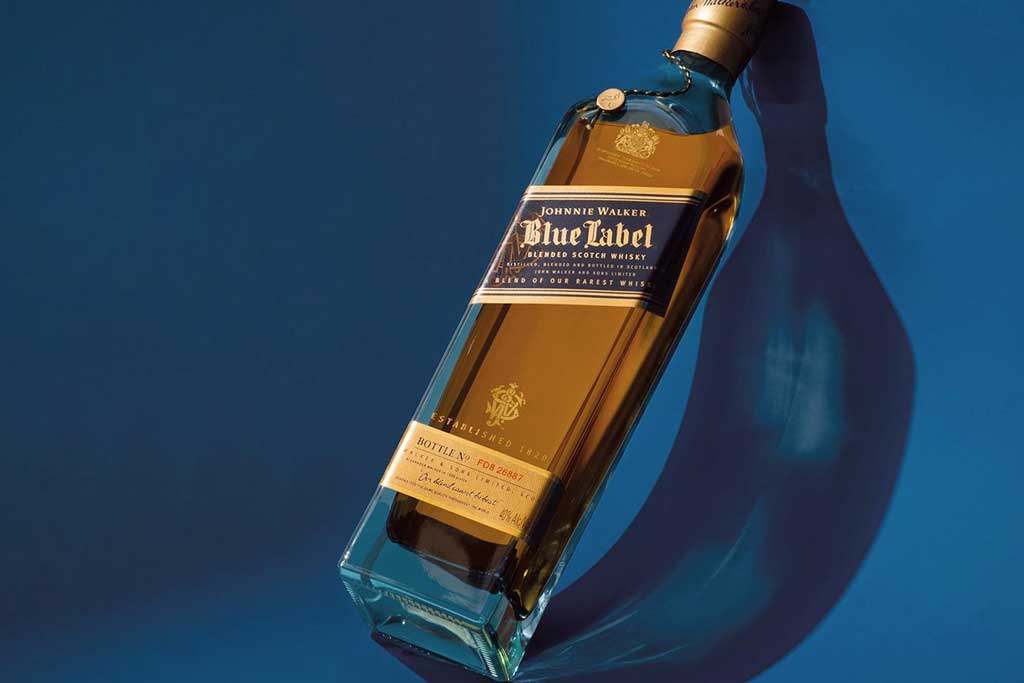 Bottle of Johnnie Walker Blue Label whisky in front of blue background