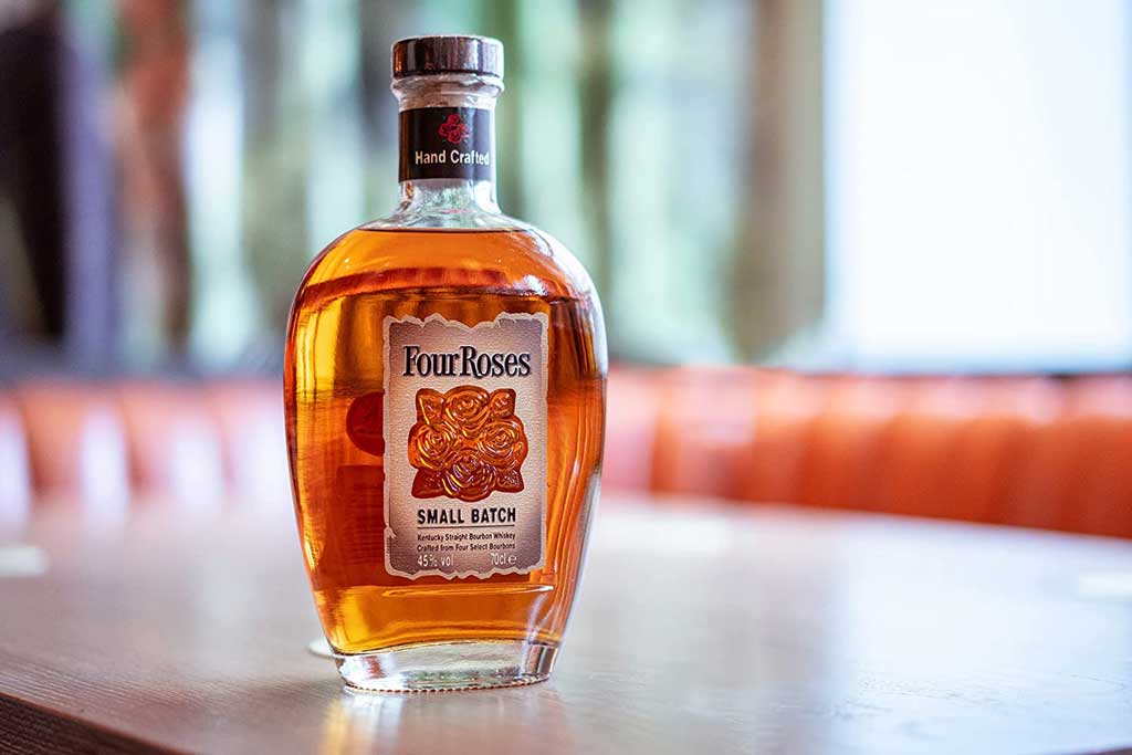 Four Roses Small Batch bourbon bottle on wooden table