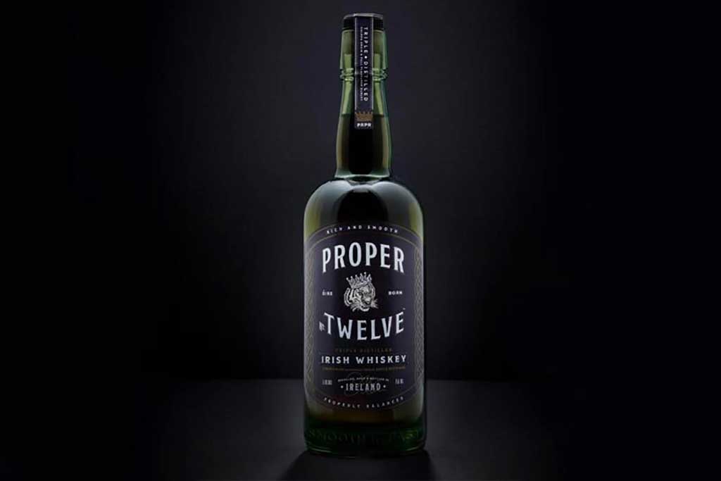 Proper No.12 Irish whiskey bottle in front of dark background