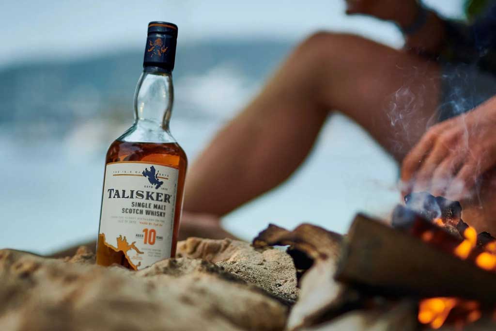 Talisker 10 year old whisky on beach beside campfire
