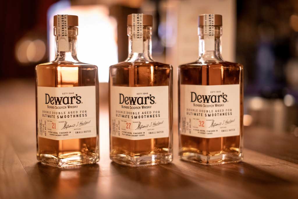 Three bottles of Dewars double double aged whiskies on table