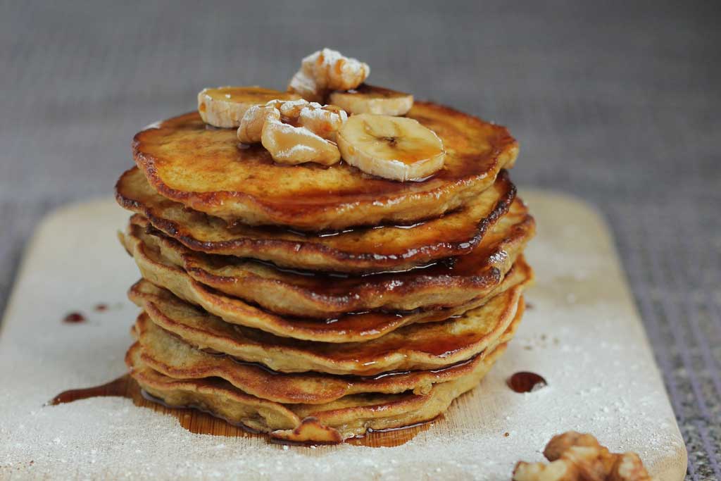 Stack of banana pancakes on square white plate