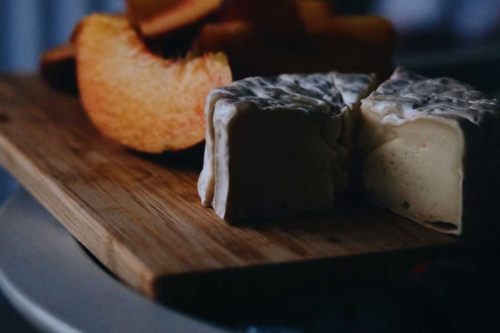 Camembert cheese on wood cutting board