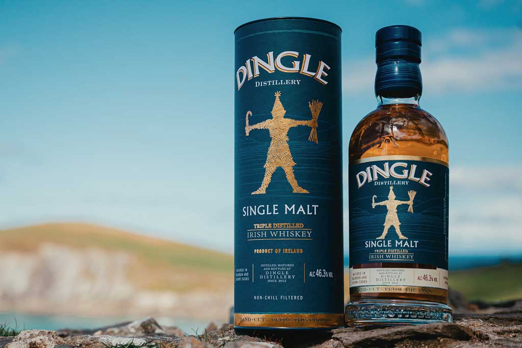 Bottle and packaging case of Dingle Single Malt Whiskey outside on Irish coastline rocks