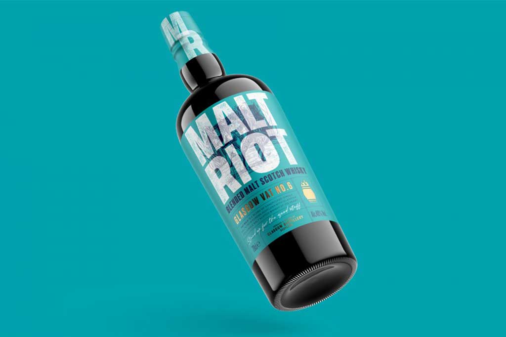 Bottle of Malt Riot blended malt Scotch whisky in front of teal blue background