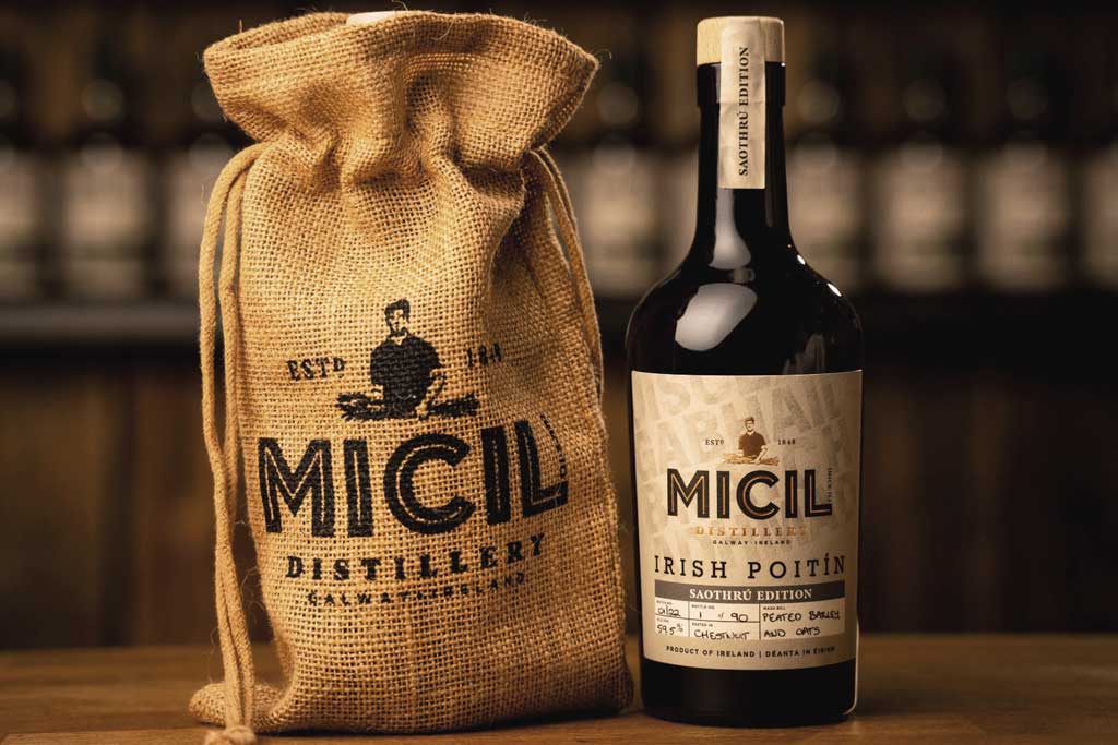 Bottle of Micil Irish Poitín on bar top beside packaging bag on bar top