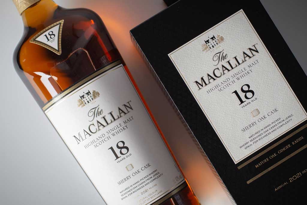 Close view of Macallan 18 Sherry Oak whisky bottle beside packaging box on white table