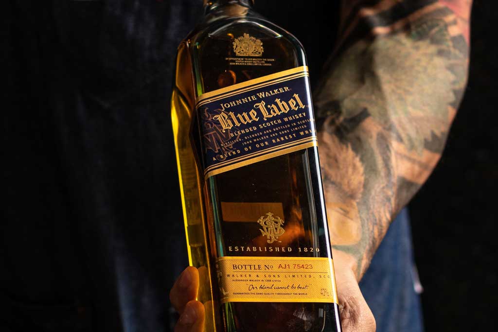 Person holding a bottle of Johnnie Walker Blue Label blended Scotch whisky