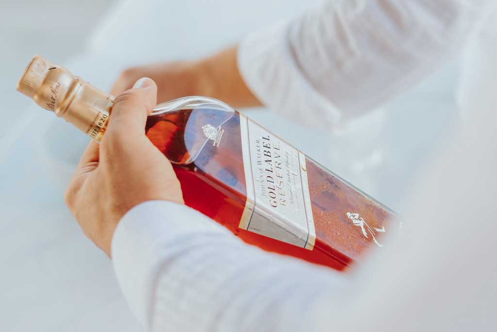 Person holding a bottle of Johnnie Walker Gold Label Reserve blended Scotch whisky