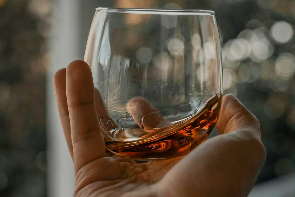 Close view of whiskey being swirled inside drinking glass